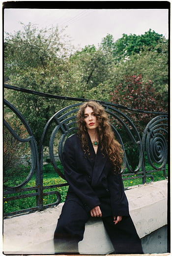 bruneta, představují, oblek, módní žena, Elegantní pozice, Svěží venkovní nastavení, elegantní oblek, Venkovní móda, kudrnaté vlasy, Černý oblek, zdobené zábradlí