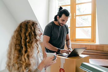 happy couple, laptop, carton box, new home, unpacking, sharing coffee, smiles, moving day, home setup, technology use, cozy atmosphere