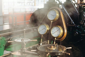 gold gauges, industrial equipment, pressure gauges, steam engine, vintage machinery, mechanical instruments, industrial gauges, gold-colored gauges, gauge cluster, industrial setting, steam-powered engine