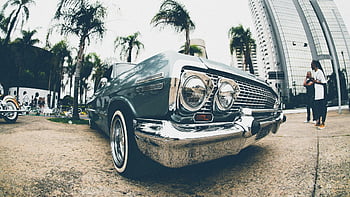 Klasik mavi Chevrolet Impala, Vintage Lowrider, kentsel sokak, şehir manzarası arka planı, Palmiye ağaçları, Yanında park edilmiş, klasik araba, kentsel ayarı, şehir hayatı, araba vitrini, sokak sahnesi