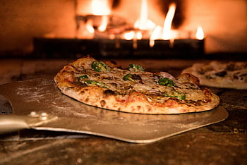 pizza, baked pizza, pizza peel, wood-fired oven, artisanal toppings, gourmet pizza, appetizing pizza, oven-baked pizza, pizza in oven, artisanal pizza, wood-fired pizza