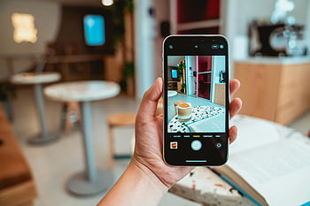 person som holder telefonen, Svart mobiltelefon, Moderne kafé, fotografere kaffe, smarttelefon, Kaféinnstilling, kaffe foto, moderne interiør, kafé interiør, håndholdte telefon, kaffe kopp