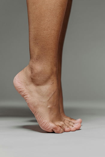 a piedi nudi, in punta di piedi, superficie bianca, minimalista, avvicinamento, piede nudo, superficie grigia, piede umano, trama della pelle, luce naturale, ombra