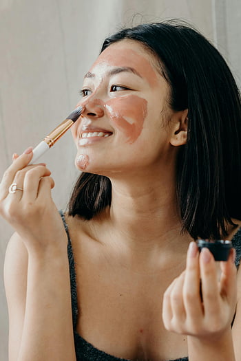 Frau, Tonmaske, Make-up Pinsel, Hautpflege-Routine, lächelnde Frau, Gesichtspflege, Schönheitsbehandlung, Selbstversorgung, Hautpflege, Schönheitsroutine, natürliche Schönheit