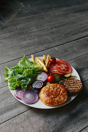 Ingredience hamburgerů, bílá deska, hranolky, texturovaný dřevěný stůl, Kulinářské fotografie, fotografování potravin, listový salát, rajče, cibule, burger patty, Sezamová buchta