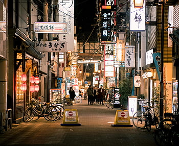 Osaka, shopping street, evening scene, illuminated signs, people walking, bustling alley, vibrant street, Japanese signs, urban nightlife, city lights, bicycles