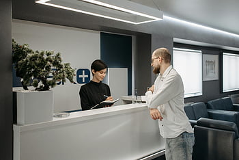 Zahnarztpraxis, Rezeptionist, Moderne Klinik, zeitgemäßes Design, Mannberatung, Klinikeinstellung, Empfangsbereich, professionelle Einstellung, Gesundheitseinrichtung, Patienteninteraktion