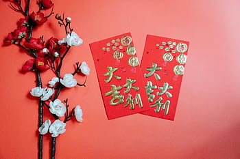 Chinese New Year, red envelopes, cherry blossoms, festive display, Oriental envelopes, decorative blooming Prunus, red background, celebratory, Chinese culture, holiday tradition, vibrant display