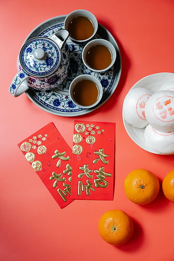 Chinese New Year, red envelopes, steamed buns, tangerines, tea set, festive setup, red background, snacks, Chinese tea, holiday decorations, cultural celebration