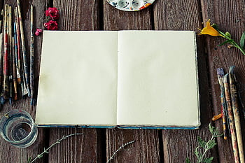 blanco schetsboek, verf kwasten, bloemen, Rustiek houten oppervlak, kunstbenodigdheden, creatieve werkruimte, Artistieke tools, Schilderopstelling, Schetsen, artistieke inspiratie, water glas