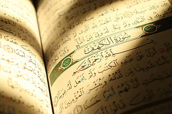 Corano, luce del sole, Corano aperto, calda luce, sceneggiatura araba, temi spirituali, pagine illuminate, testo religioso, libro sacro, Scritture islamiche, letteratura sacra