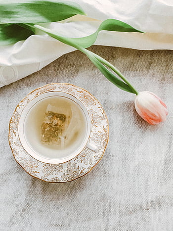 růžové květy, šálek, podšálek, Květinový porcelánový pohár, růžový Tulipán, bylinkový čaj, Jemná čajová scéna, květinovým vzorem, čajový sáček, bílý hadřík, zelené listy