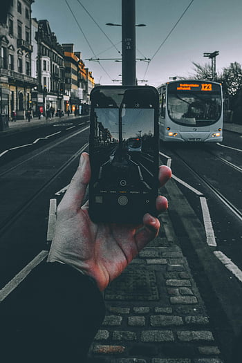 smartphone, interfaccia della fotocamera, via della città, autobus, crepuscolo, mano che regge, i phone, scena urbana, tram, sera, fotografia di strada