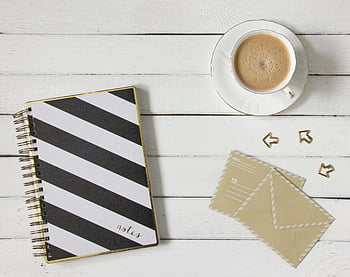bílý keramický šálek, hnědá kapalina, pruhovaný notebook, kávový šálek, obálky, dřevěný stůl, flatlay, kancelářské potřeby, pracovního prostoru, papírnictví, nastavení stolu