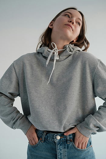 calm woman, casual wear, stylish woman, hoodie, jeans, studio pose, self-assured expression, gray hoodie, denim jeans, confident look, studio photography