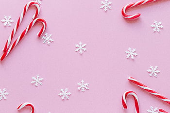 candy canes, red and white stripes, pink surface, festive background, winter holiday, snowflakes, holiday themes, Christmas decorations, candy cane design, pink backdrop, winter festive