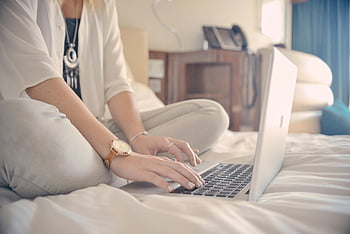 woman, gray laptop, computer, working, bed, home office, casual, typing, wristwatch, comfortable, indoor