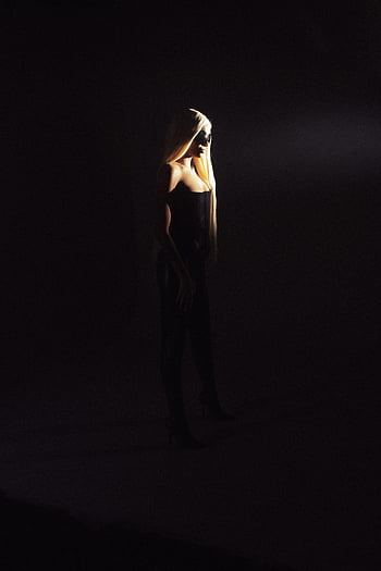 blonde model, leather pants, high heels, fashion portrait, dramatic lighting, silhouette, spotlight, dark background, stylish outfit, elegant pose, black attire