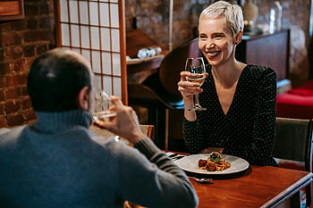 romantic dinner, smiling woman, wine glass, cozy restaurant, couple, enjoying wine, dinner date, romantic atmosphere, cozy setting, romantic couple, dining experience