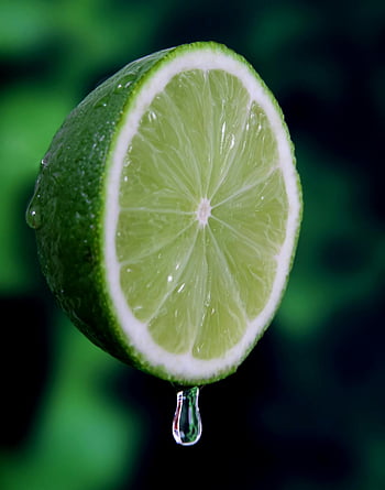 sliced lime, macro shot, juicy lime, fresh lime, water droplet, vibrant green, lime slice, citrus fruit, close-up photography, lime juice, green color