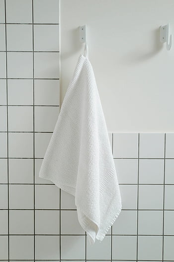 Bílý ručník, visící ručník, moderní koupelna, kachlová stěna, koupelna dekor, Háček ručníku, jednoduchý design, bílé dlaždice, Koupelnové doplňky