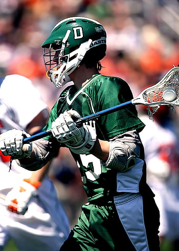 lacrosse player, green uniform, outdoor game, green and white helmet, focused athlete, lacrosse stick, sports action, team sport, competitive game, green jersey, white gloves