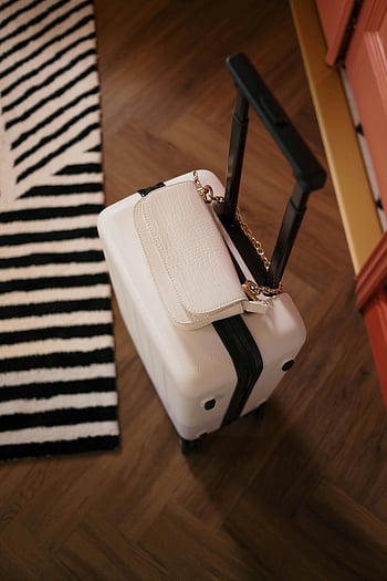 valigia bianca, Borsa elegante, pavimento di legno, tappeto a strisce, vista dall'alto, borsa sulla valigia, bagaglio di viaggio, accessorio di moda, impostazione interna, arredamento moderno, cinturino a catena