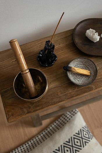třecí miska a tlouček, hnědý dřevěný stůl, palo santo, kadidlo, Meditační nastavení, léčivé krystaly, klidná atmosféra, dřevěný stůl, Meditační nástroje, aromaterapie, relaxace