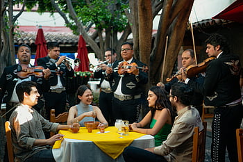 Mariachi Band, Mexikanisches Restaurant im Freien, Lebhafte Versammlung, Freunde essen, Veranstaltung im Freien, mexikanische Musik, traditionelle Mariachi, Menschen versammeln, Essen im Freien, kulturelle Veranstaltung, Festliche Atmosphäre