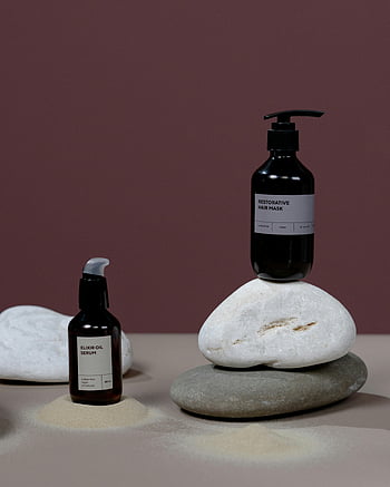 Bio -Haarpflegeprodukte, beschriftete Flaschen, Steine, Studioaufnahme, minimalistisches Design, Elixieröl -Serum, restaurative Haarmaske, natürliche Schönheit, Produktfotografie, Haarpflege, Steinanzeige