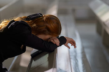 woman leaning on bench, redheaded woman, deep prayer, church pew, serene atmosphere, prayerful woman, church interior, peaceful moment, religious setting, contemplative pose, spiritual reflection