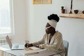 Vrouw die vanuit huis werkt, Afro-Amerikaanse vrouw, Schrijven in dagboek, werken vanuit huis, laptop, thuiskantoor, opstelling van het bureau, afstandswerk, gericht werk, thuiswerkruimte, natuurlijk licht