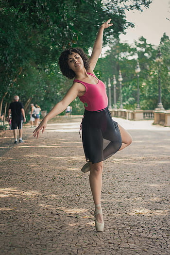 woman dancing, ballet dancer, park setting, outdoor dance, elegant performance, skill and poise, ballerina, dance pose, natural setting, ballet shoes, park pathway