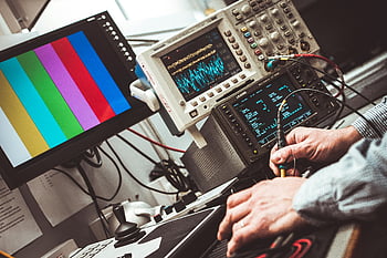 electronic testing, measurement devices, technician operating, laboratory equipment, colorful display, oscilloscope, test probes, control panel, technical setup, electronic devices, lab technician