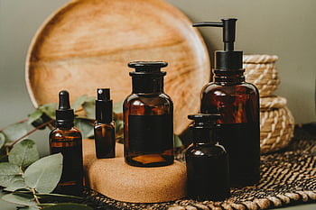 bruine flessen, Amber glazen flessen, rustieke achtergrond, Schoonheidsproduct presenteert, esthetische opstelling, schoonheidsproducten, natuurlijke schoonheid, milieuvriendelijke producten, vintage flessen, essentiële oliën, huidverzorgingsproducten