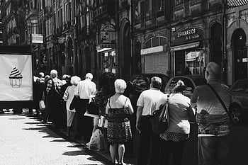 lidé v řadě, Monochromatická pouliční fotografie, fronta lidí, staré budovy, městském prostředí, Černý a bílý, pouliční scény, městský život, Veřejná fronta, pouliční fotografie, městské fotografie