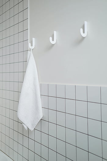 bílý ručník, Bílá kachlová koupelna, minimalistická koupelna, Čistá koupelna, bílé háčky, jednoduchost, hygiena, bílé dlaždice, Háčky ručníku, bílé stěny, bílý dekor