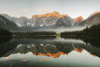 Lago Puro, montagne Rocciose, riflessione di montagna, Lago sereno, paesaggio nebbioso, vegetazione lussureggiante, bellezza naturale, scena tranquilla, vista delle montagne, acque calme, Sunrise Glow