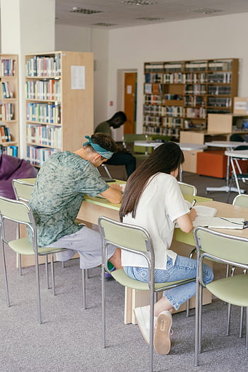 Muž a žena psaní, knihovna, dospělí studenti, studovat, Útulná univerzitní knihovna, učení se, stůl, knih, regály, židle, životní prostředí