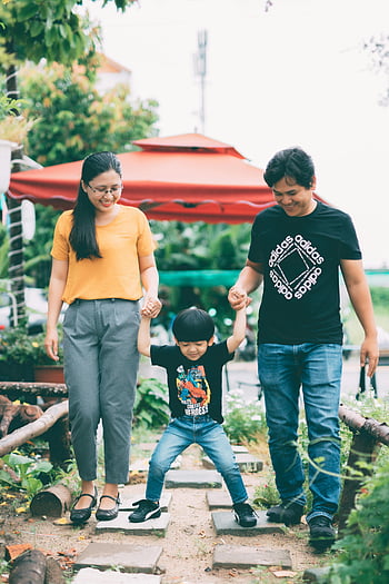 Familie, Verspieltes Kind, Händchen halten, Freude Familie, im Freien gehen, Verspielter Moment, Eltern, Kind, draussen, Familienzeit, Glück