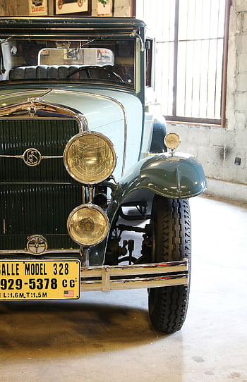 classic gray vehicle, vintage car, historical license plate, museum setting, close-up, classic car, vintage automobile, indoor display, classic auto, historical vehicle, museum exhibit