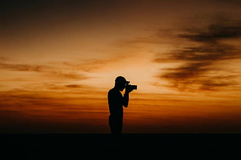 fotografia do sol, fotógrafo de silhueta, Céu laranja, Dusk Photography, céu crepuscular, Captura de momentos, homem com câmera, laranja vibrante, Silhueta do crepúsculo, momento perfeito, fotografia crepuscular