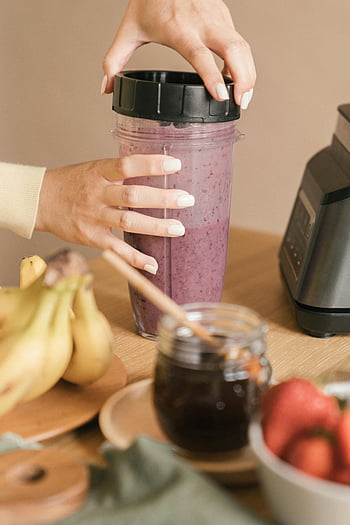 Mani con bicchiere, frullato di frutta fresca, contenitore frullatore, banane, miele, mangiare sano, Smoothie Making, miscela di frutta, bicchiere di plastica, uno stile di vita sano, frullato di frutta