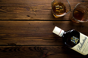 Ballantinova láhev, skalní brýle, Rustikální dřevěný stůl, láhev whisky, Témata baru, Témata oslav, pohled shora, smíšené skotské whisky, ledové kostky, dřevěný povrch, Nastavení nápoje