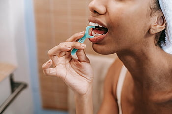 ethnic woman, dental floss, oral hygiene, daily care, close-up, dental floss pick, teeth cleaning, woman using floss, promoting hygiene, tooth care, bathroom setting
