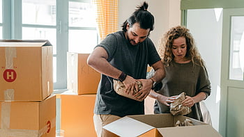 diverse couple, packing belongings, parchment, different boxes, indoors, unpacking boxes, bright living room, new beginning, moving day, home relocation, couple moving