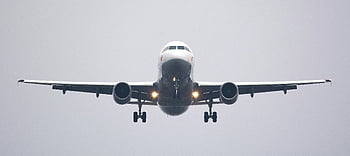 commercial airliner, time lapse photography, white airplane, cloudy sky, preparing to land, head-on view, commercial airplane, landing aircraft, aviation photography, airplane landing, cloudy weather
