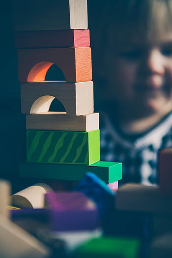 wooden blocks, green blocks, brown blocks, colorful blocks, child playing, building structures, creative play, toy blocks, educational toys, indoor play, children's toys