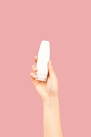 Botol memegang tangan, Botol kosmetik putih, latar belakang merah muda, tema kecantikan, tema perawatan kulit, tangan close-up, wadah plastik putih, produk kecantikan, produk perawatan kulit, desain minimalis, estetika bersih