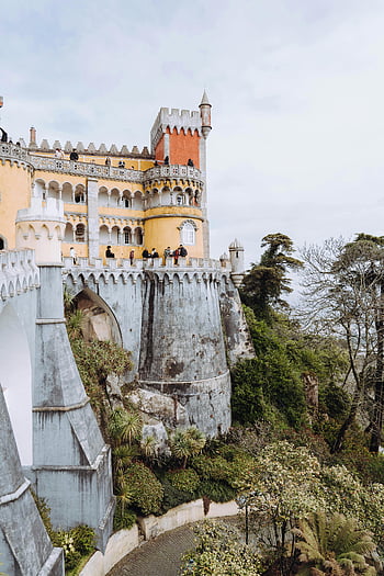 Pena Palace, Sintra, colorful palace, lush greenery, tourist landmark, palace on a hill, breathtaking view, Sintra Portugal, historic architecture, European castle, travel destination